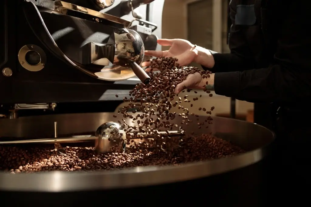 A detailed shot of a large, professional coffee roasting machine in action.