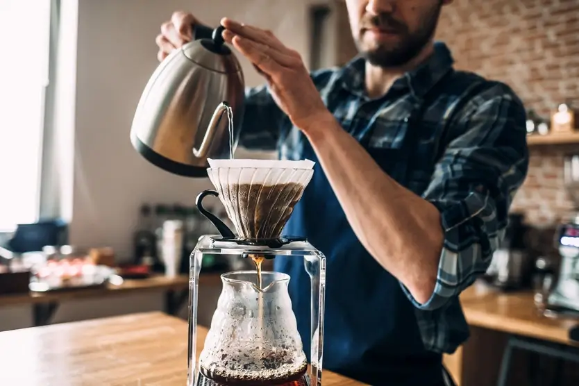 A person using a pour-over method to brew coffee.