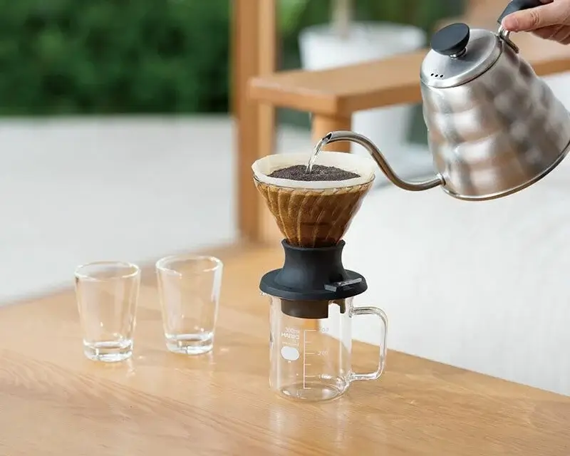 An organized set of pour-over equipment: kettle, dripper, filter, and scale.